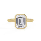 Shop MYZA's 2 carat IGI certified emerald cut lab-grown diamond bezel set engagement ring in 18K hallmarked gold. Ethical luxury, certified brilliance.