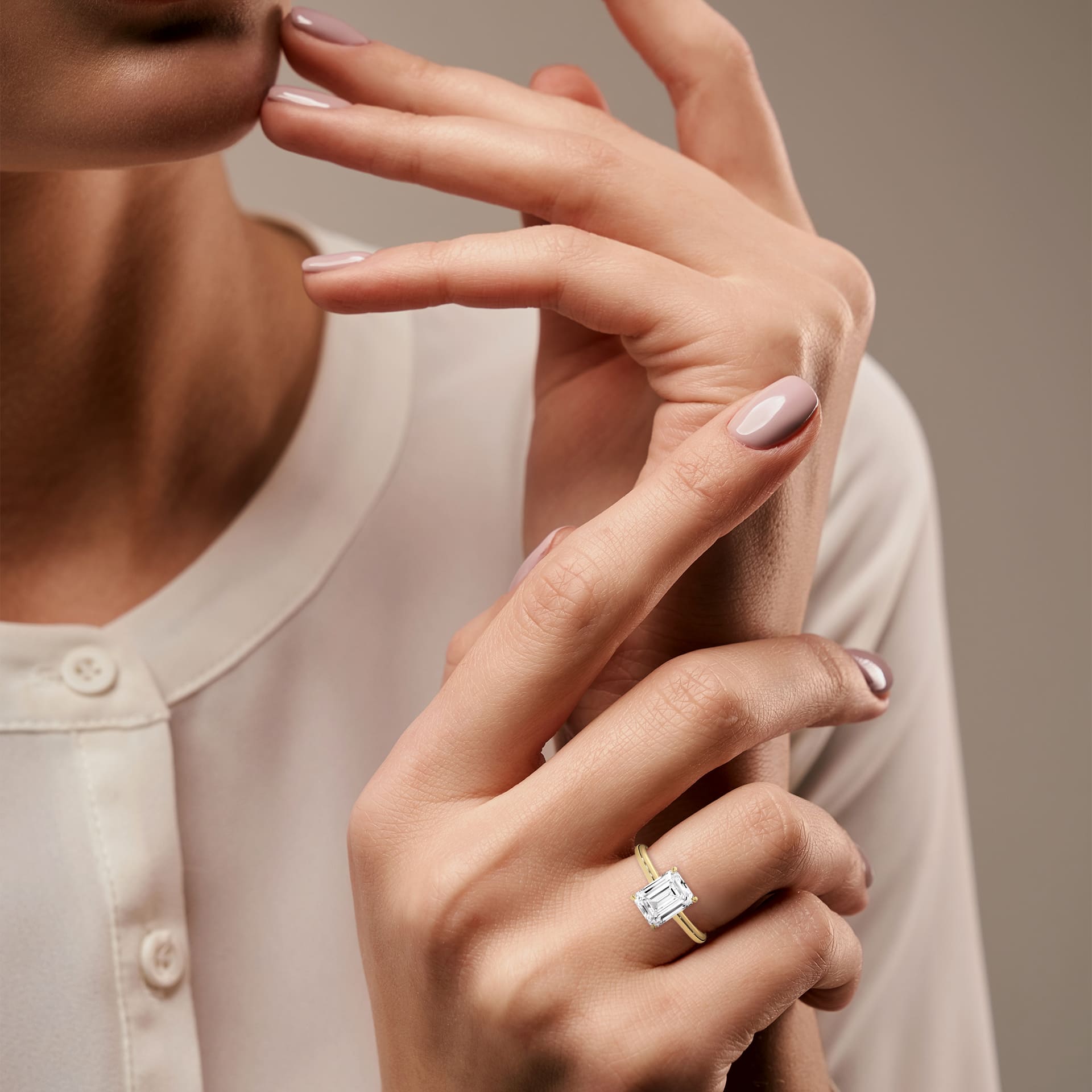 all-groups Close-up of a woman's hand wearing MYZA Diamonds' emerald cut lab-grown diamond classic band ring in 18K hallmark gold. The elegant design features a stunning lab-grown diamond, making it a perfect choice for a luxurious, sustainable engagement or wedding ring.