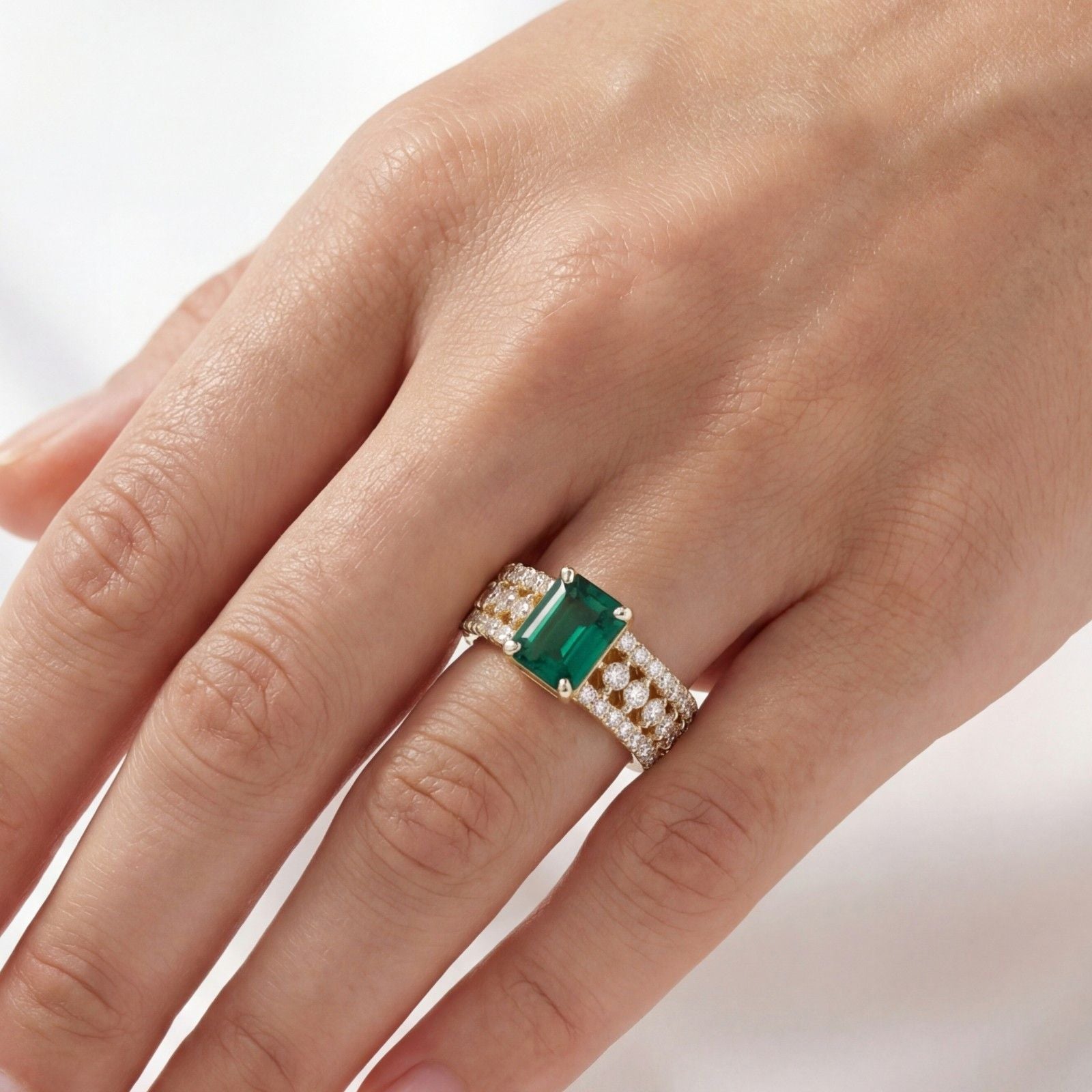 This MYZA Certified 1.5 Carats Emerald Cut Zambian Green Women's Ring  features a vivid lab-grown Zambian emerald in a 14K hallmarked gold setting, offering a sleek, sophisticated balance of classic step-cut elegance and brilliant diamond accents.