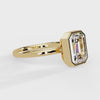 Shop MYZA's 2 carat IGI certified emerald cut lab-grown diamond bezel set engagement ring in 18K hallmarked gold. Ethical luxury, certified brilliance.